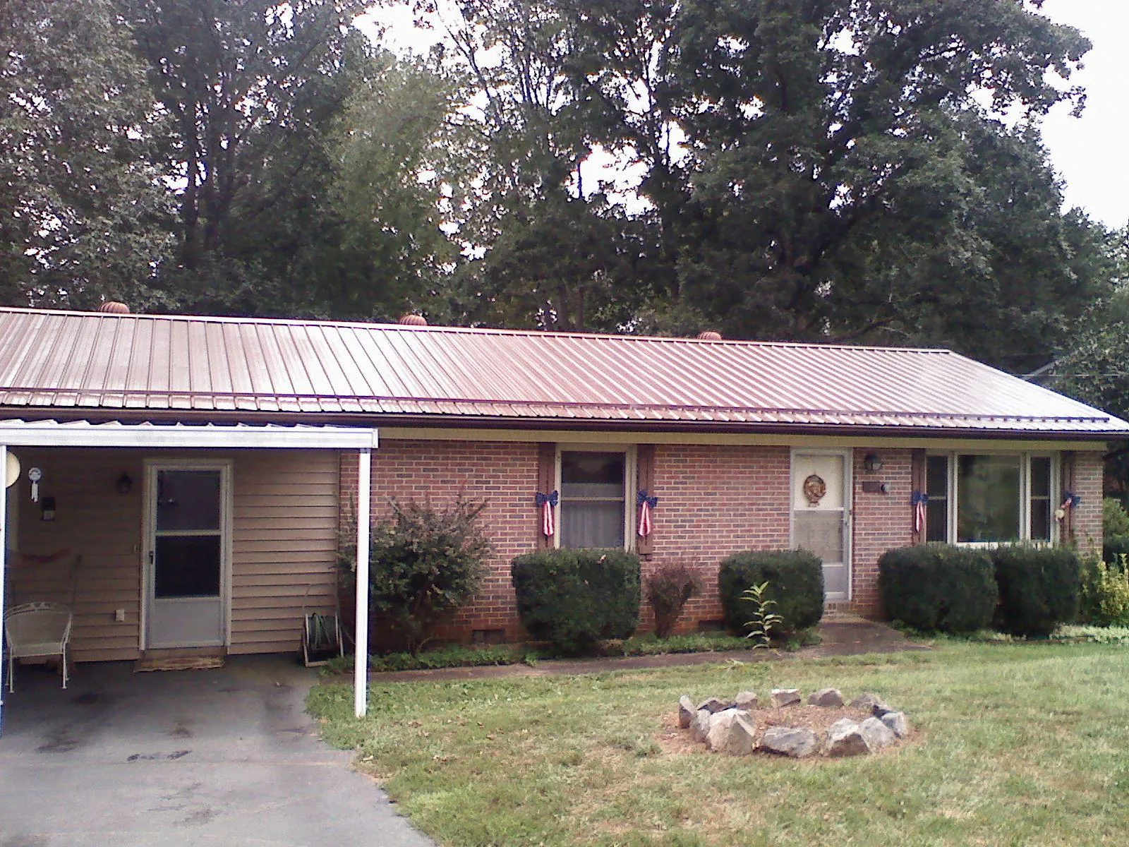 Bronze metal roof and carport on a brick ranch home — Roof Repair work by our crew in Bevington